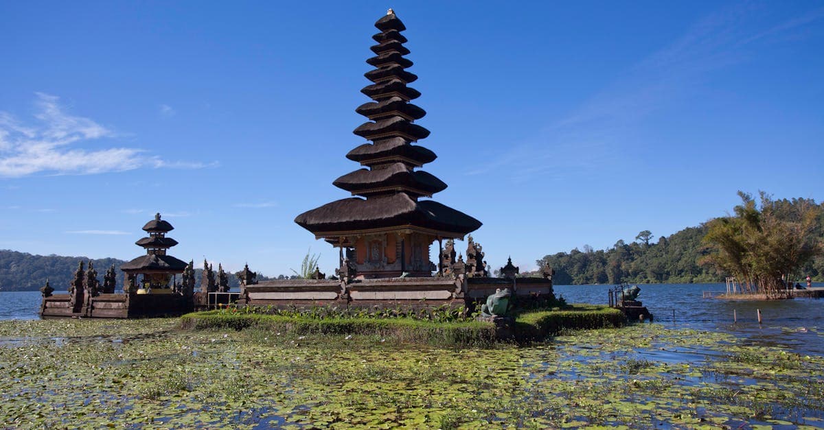 Ulun Danu Temple reflected in calm lake waters demonstrates peak bali weather conditions during dry season.