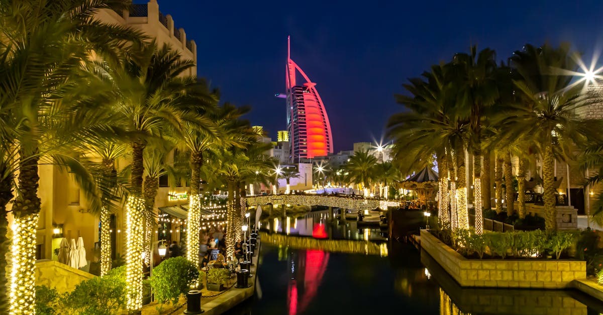 Burj Al Arab lit up at night beside Dubai's canal, comparing travel eSIM options for South African visitors
