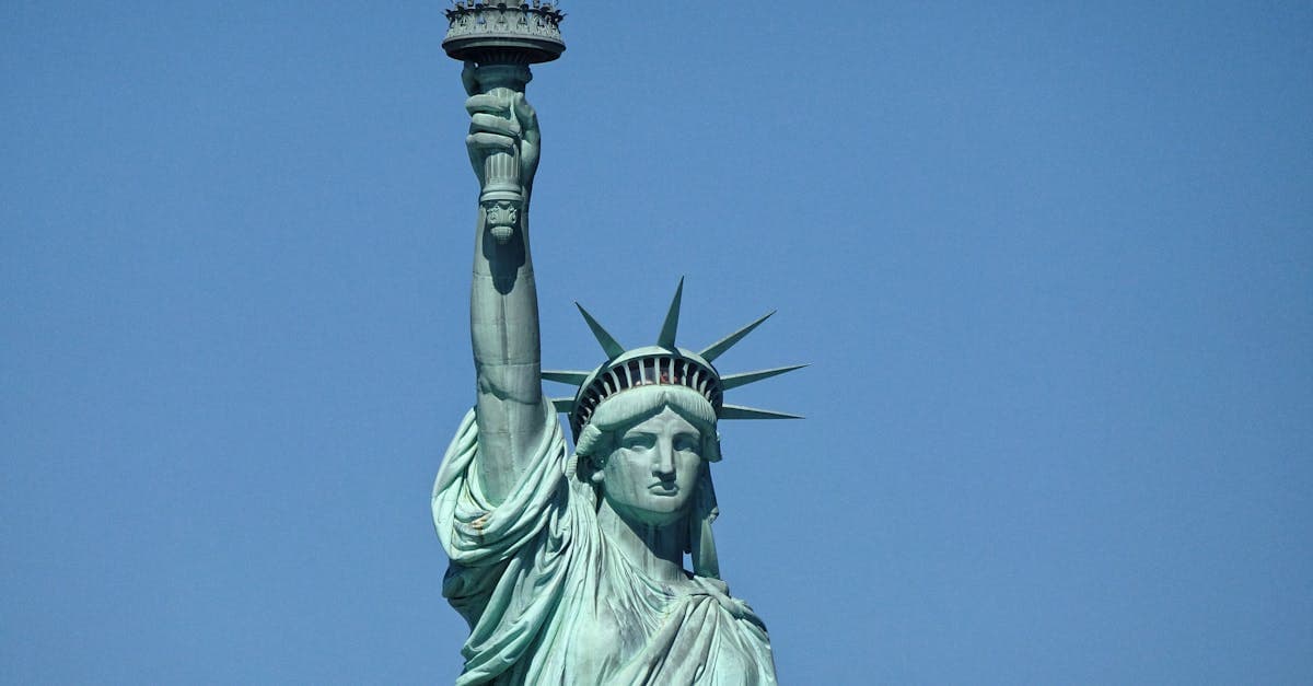 Detailed close-up of the Statue of Liberty against a clear blue sky in New York City.
