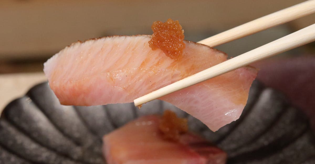 精緻生魚片以筷子夾起點綴魚卵,呈現台北鼎泰豐與米其林星級餐廳的頂級料理。