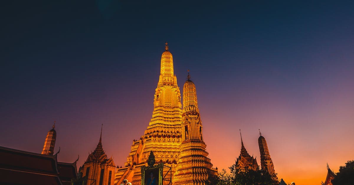 Wat Arun temple glowing at dusk as South Africans verify their phone's esim thailand compatibility before flying