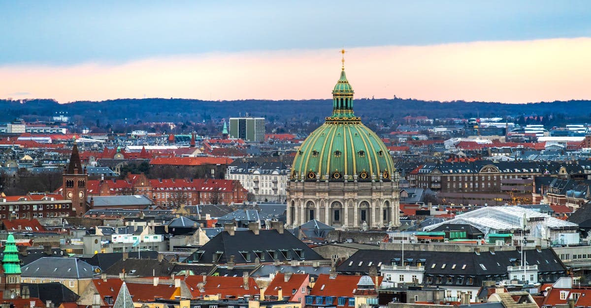 Luftfoto af Frederiks Kirke og Københavns skyline ved solnedgang – hjem til danske skatteregler for udlandsarbejde.