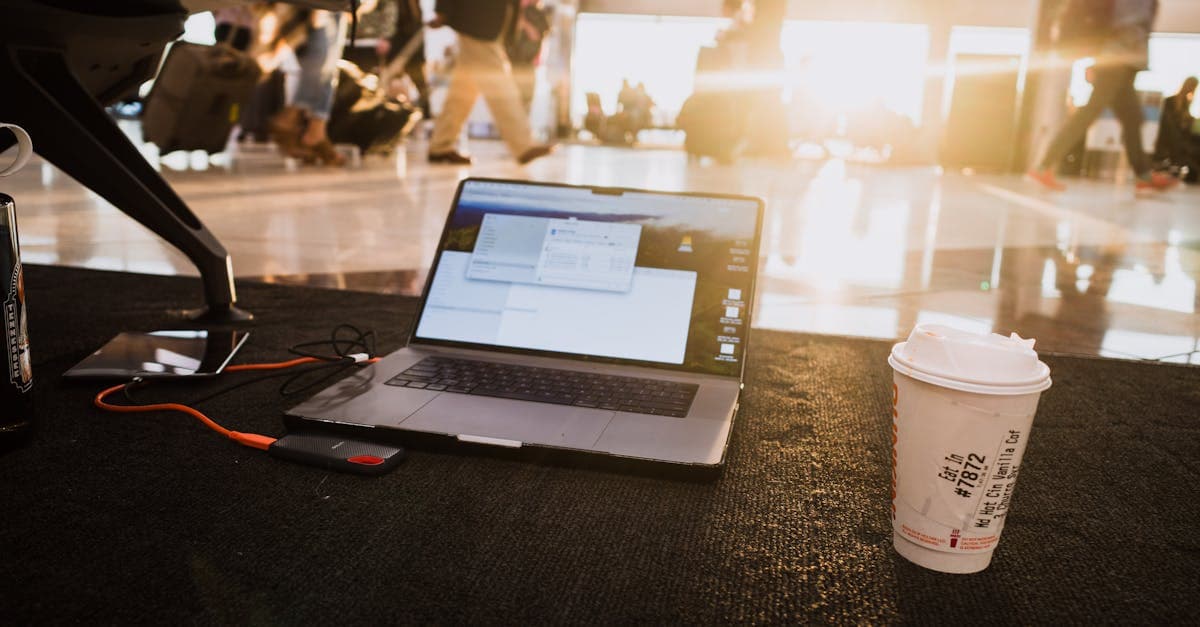 Laptop and coffee at busy airport terminal demonstrating portable wifi connectivity for work travel