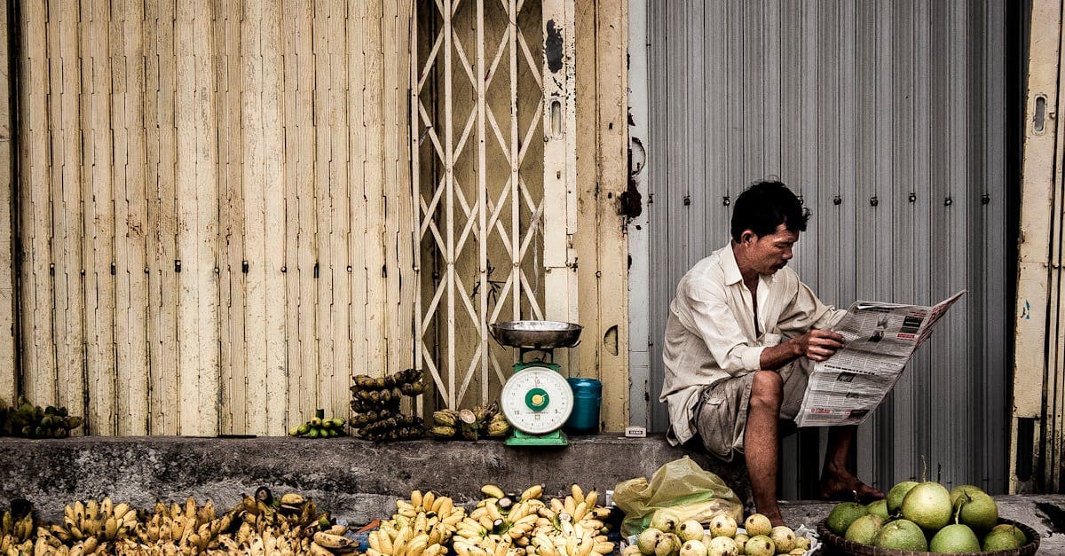 Vietnamese marktverkoper naast verse tropische vruchten op een straatmarkt in Ho Chi Minh City.