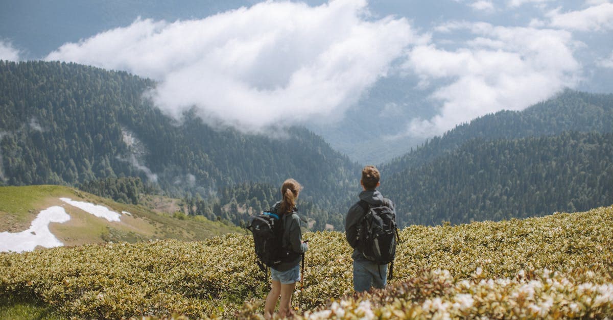 Two backpackers with full packs admiring a mountain vista while exploring the cheapest countries to travel in 2026