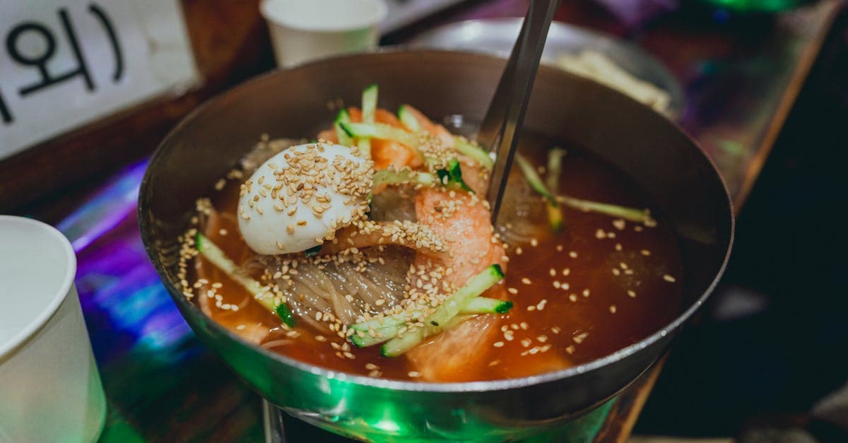 Cold Korean naengmyeon noodles topped with vegetables and sesame seeds, a traditional Seoul dish.