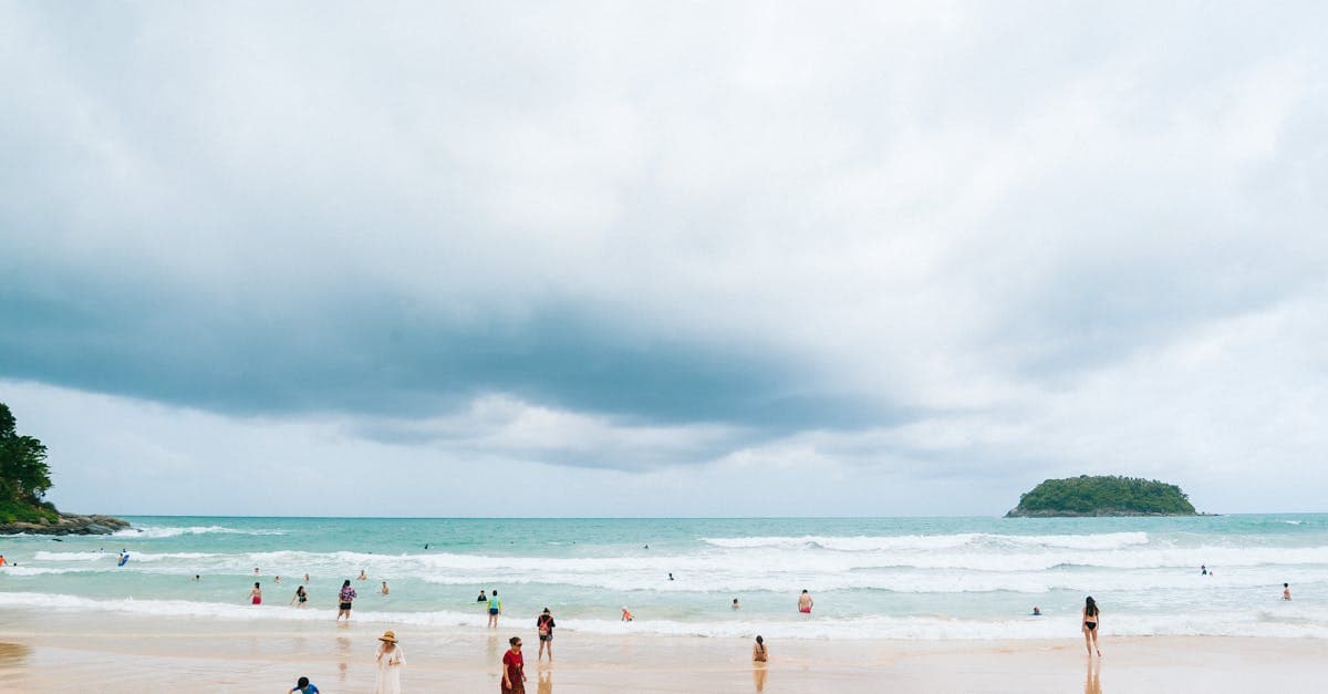 Beachgoers enjoying Kata Beach in Phuket during a dry spell in thailand weather's rainy season