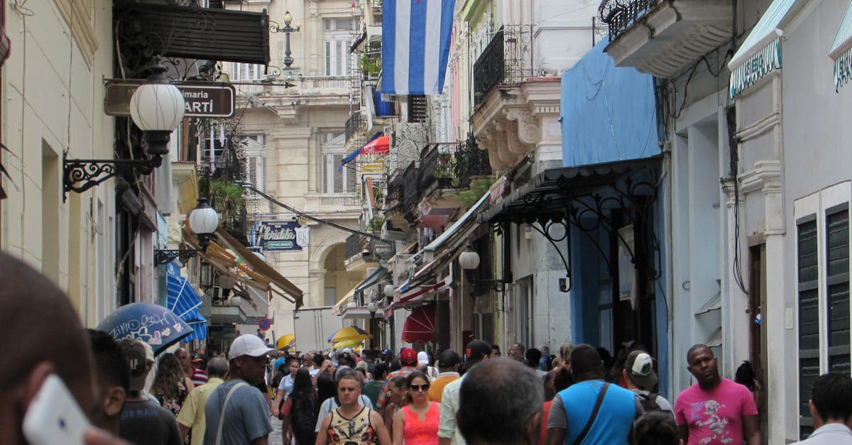 Rue animée Calle Obispo à La Havane avec foule et drapeau cubain, vie quotidienne lors de cheap trips to cuba
