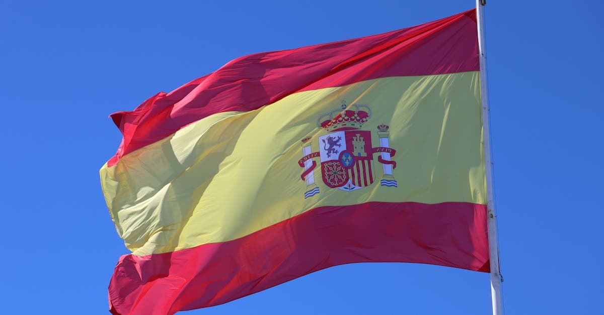 Spanish flag waving under clear blue sky representing the choice between EU roaming and esim spain