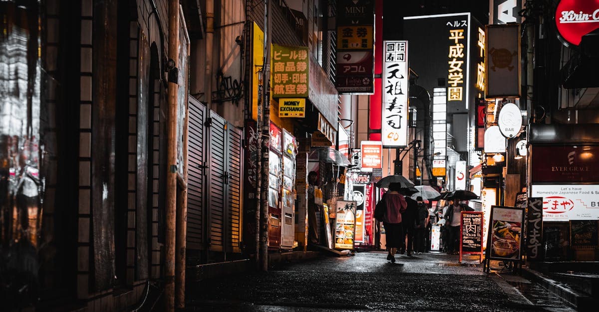 Folla con ombrelli percorre le vie neon di Tokyo di notte: trova la migliore esim giappone per il tuo soggiorno