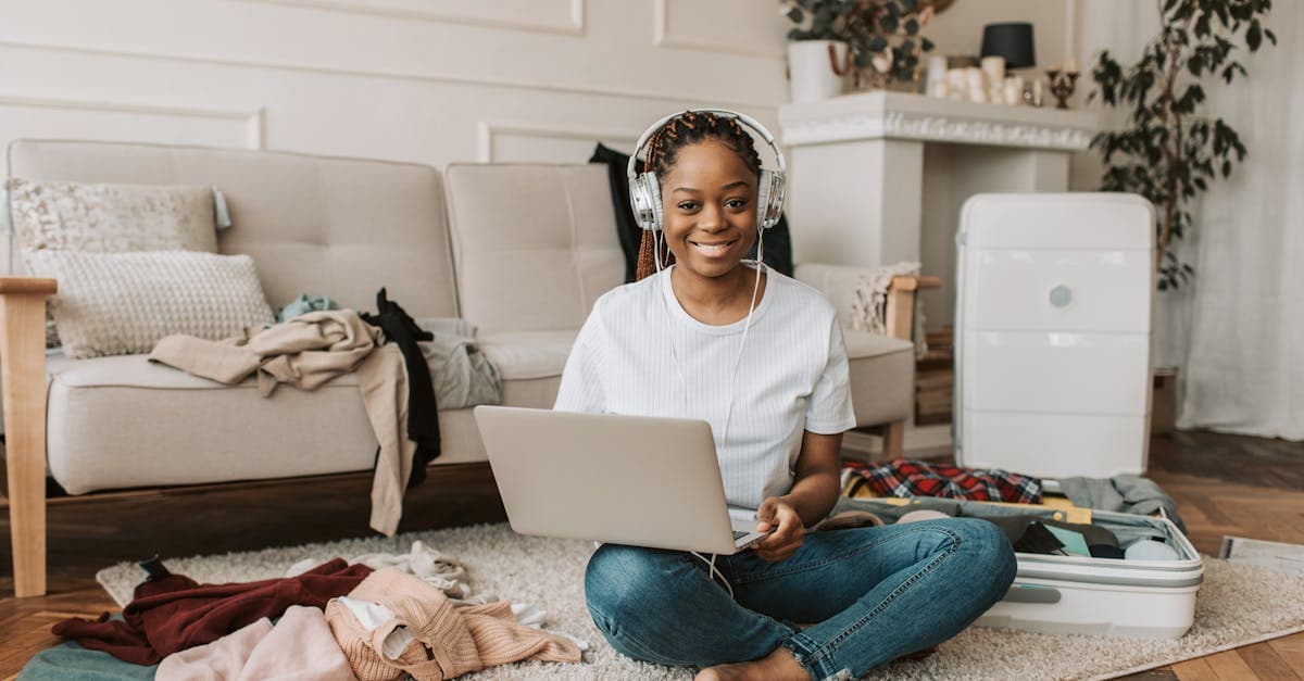 Woman using a laptop while packing a suitcase, researching how to stay connected in Ireland