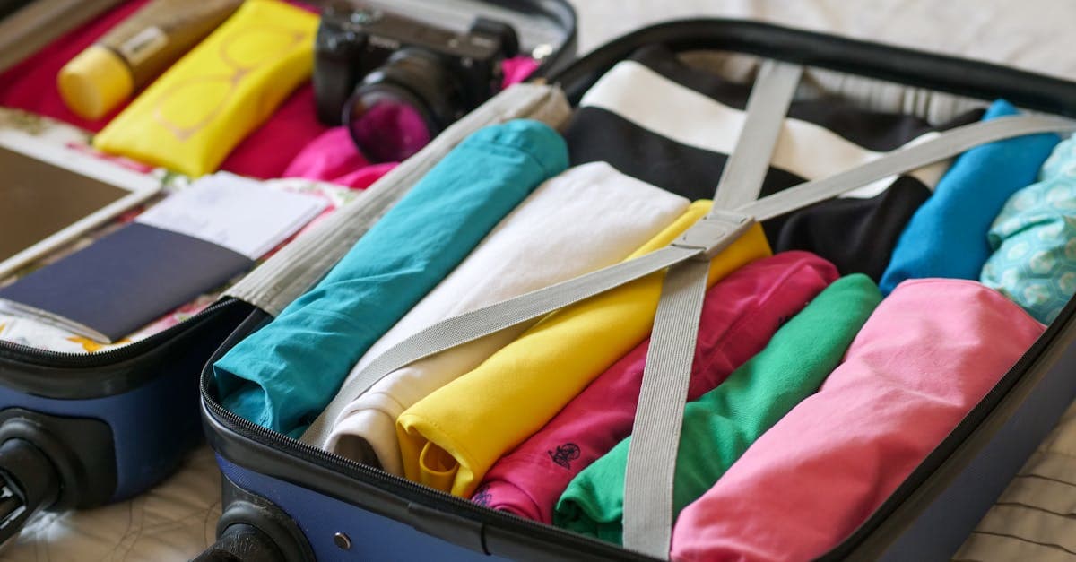 Open suitcase packed with clothes, gadgets, and travel essentials covered under backpacker insurance baggage limits