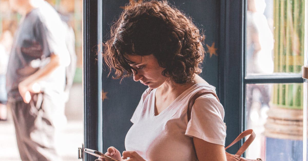 한국 번호로 OTP 문자를 받으며 스마트폰을 확인하는 여성, 창가에서 밝은 빛 아래