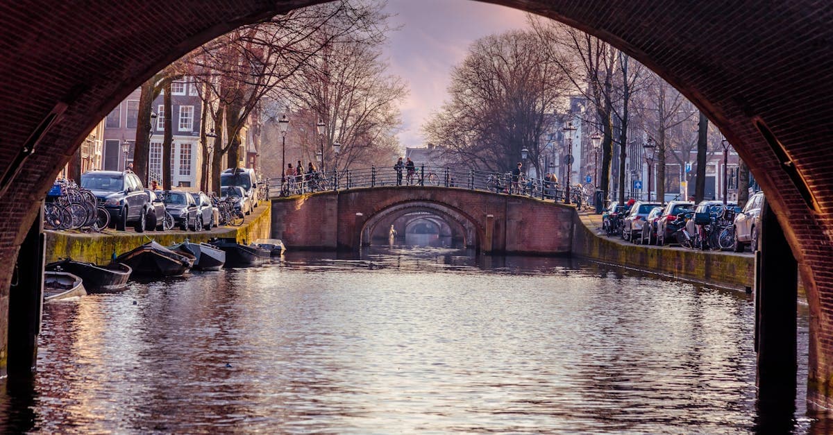 Amsterdam canal viewed through a bridge arch, essential inspiration for Irish travellers planning things to do in amsterdam