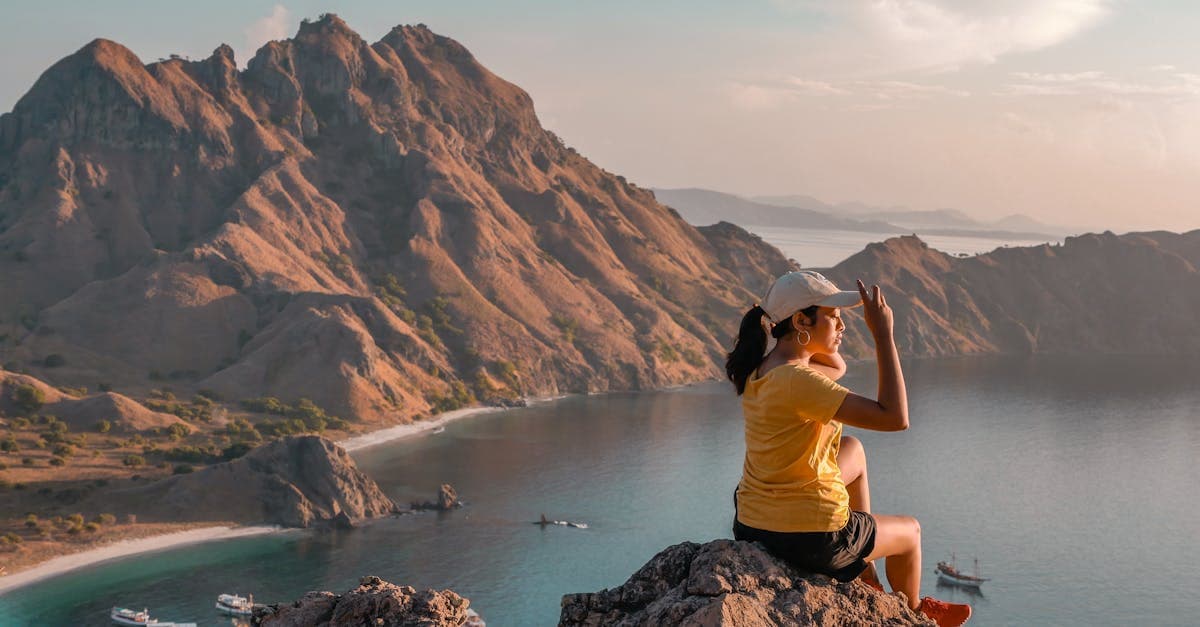 Mulher contempla o nascer do sol na Ilha Padar, Indonésia, um dos melhores destinos para viagem solo feminina