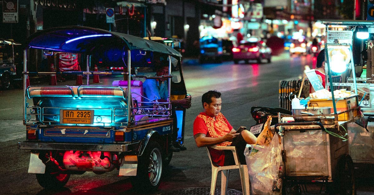 Farbenfrohe Nachtszene mit Straßenverkäufer und Tuk-Tuk in Thailand – beliebtes Reiseziel für den europäischen Winterurlaub