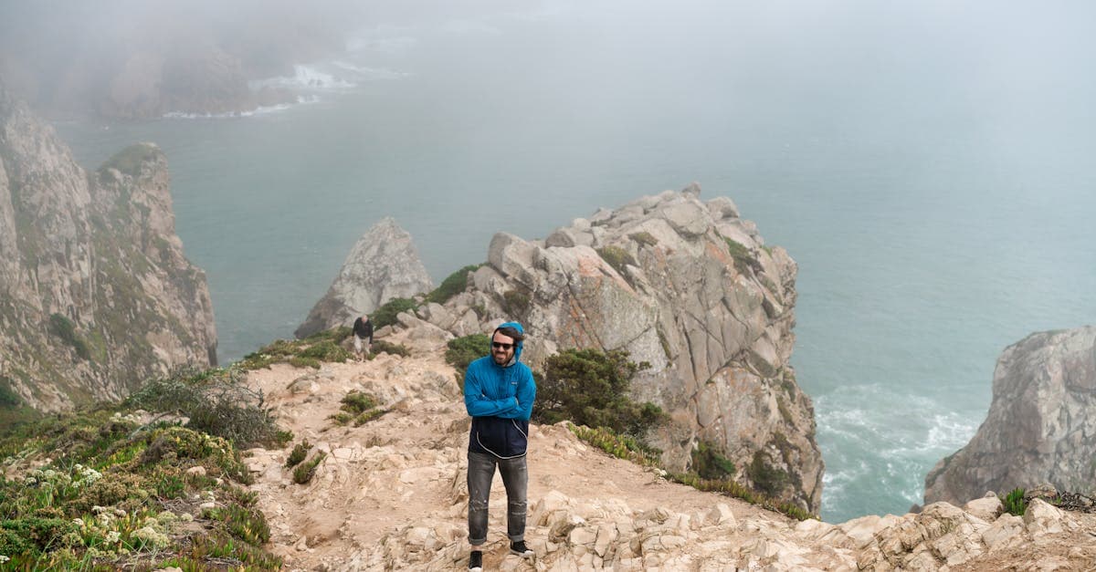 Solo traveler standing on a European coastal cliff, weighing the costs of a solo trip europe from South Africa