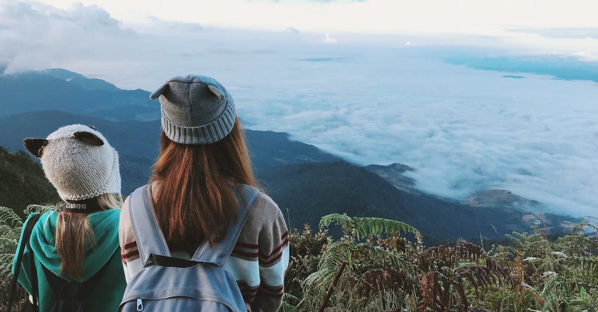 Two women with backpacks admiring misty mountain views in northern Thailand near Chiang Mai