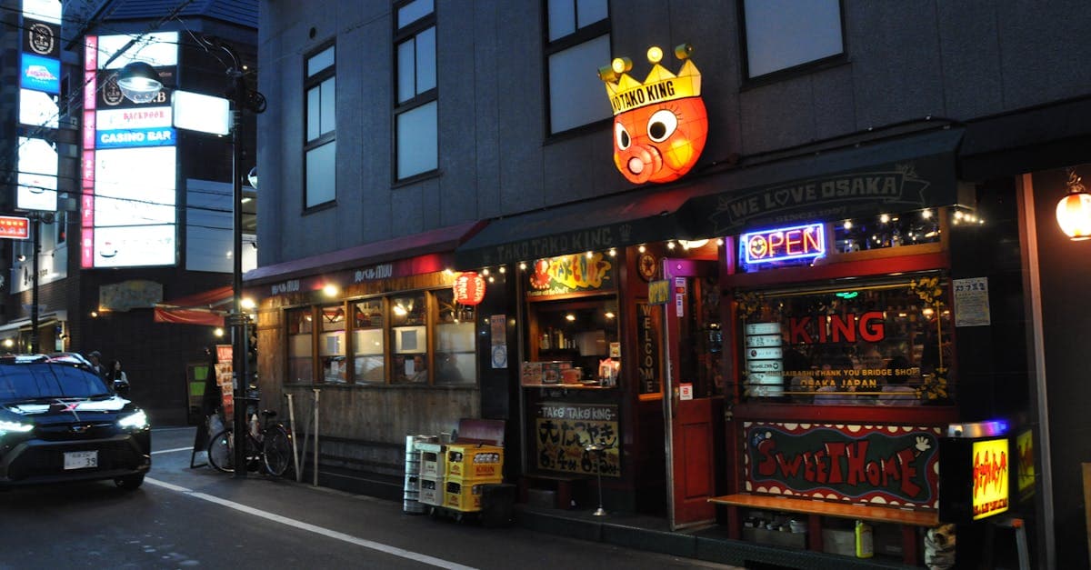Fachada iluminada de restaurante de takoyaki em Osaka ao entardecer, ícone da comida de rua japonesa.