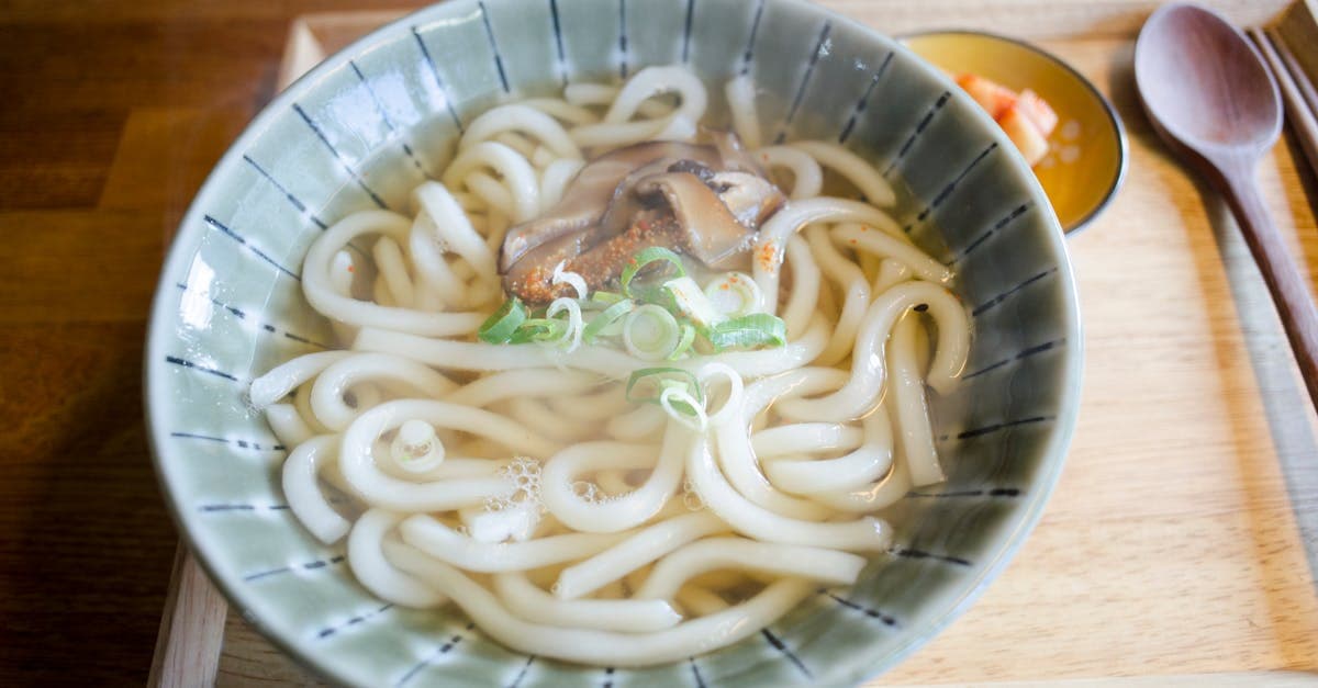 Tigela aquecida de sopa de udon com cogumelos e cebolinha, especialidade da culinária japonesa