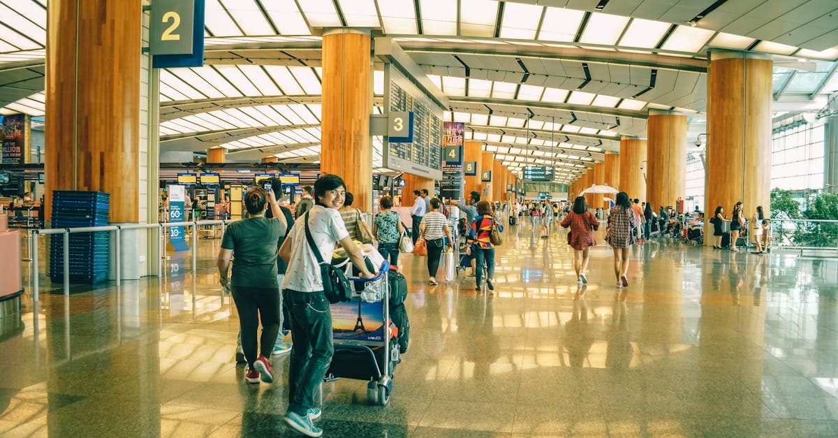 Travelers bustling through Changi Airport terminal comparing Scoot and Jetstar Asia airfare costs