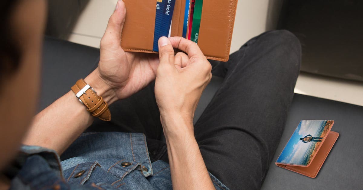 Homme tenant un portefeuille avec cartes pour gérer ses finances et sa connectivité lors d'un PVT