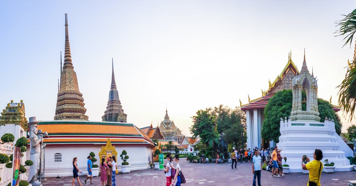 Tourists exploring Wat Phra Chetuphon temple in Bangkok, one of the best times to visit for budget travel southeast asia