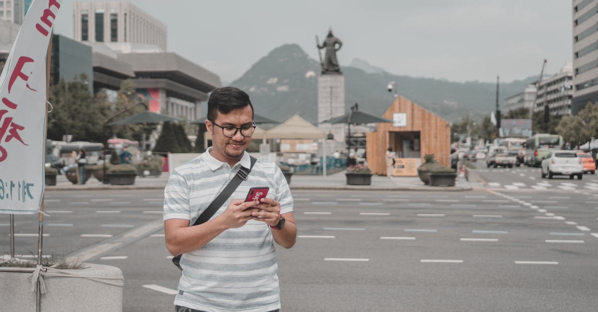 도심 스카이라인을 배경으로 스마트폰을 사용하는 남성, 솔로 여행자에게 필수인 트래블 eSIM 활용 장면