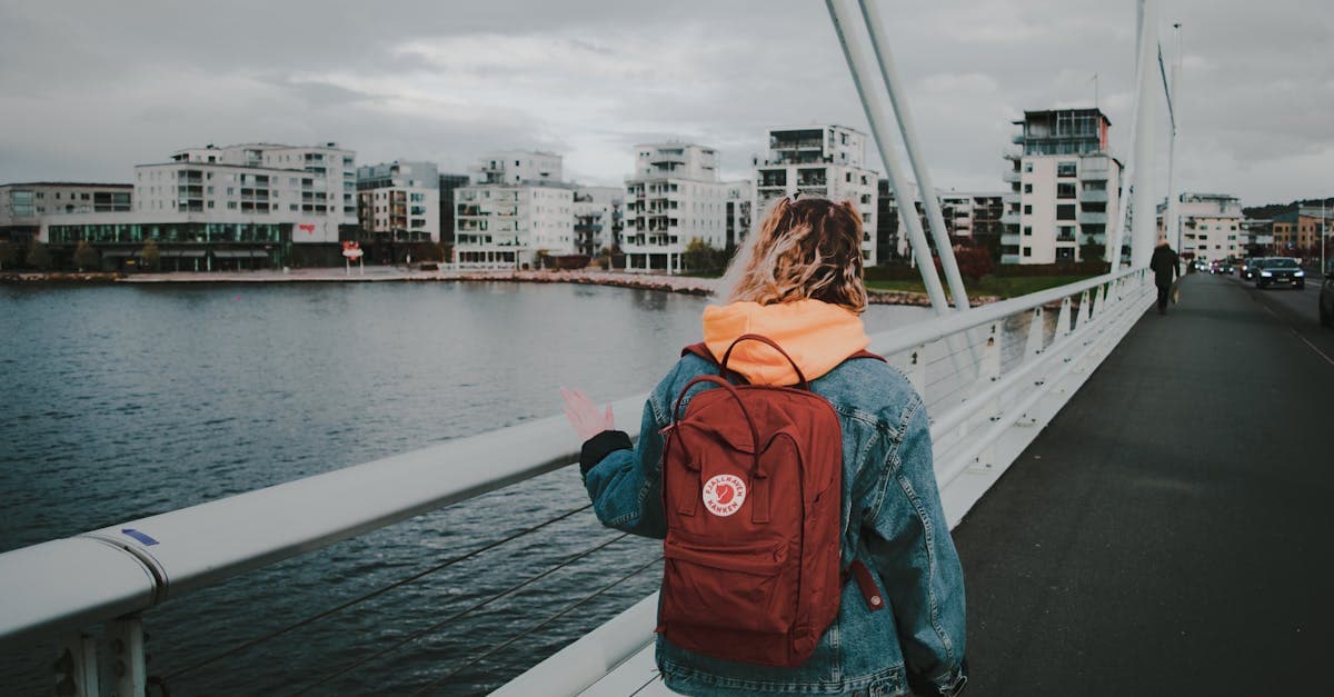 Kvinna i jeansjacka promenerar på bro i Jönköping – dataroaming håller dig uppkopplad var du än är.