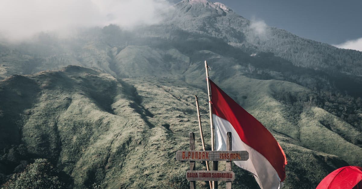 Bendera Indonesia berkibar di depan latar pegunungan hijau, mewakili daftar negara bebas visa indonesia