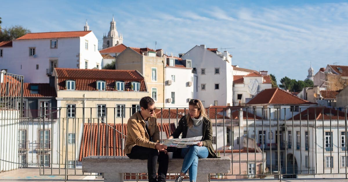 Casal com mapa observa os telhados de Lisboa ao planejar o que fazer em portugal
