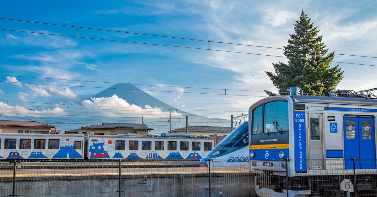 รถไฟฟูจิคิวผ่านหน้าภูเขาไฟฟูจิในวันท้องฟ้าแจ่มใส สัญลักษณ์การเดินทางในญี่ปุ่น