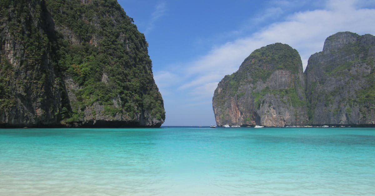 Tranquil Thai beach with turquoise waters and limestone cliffs for cheap vacation exploration
