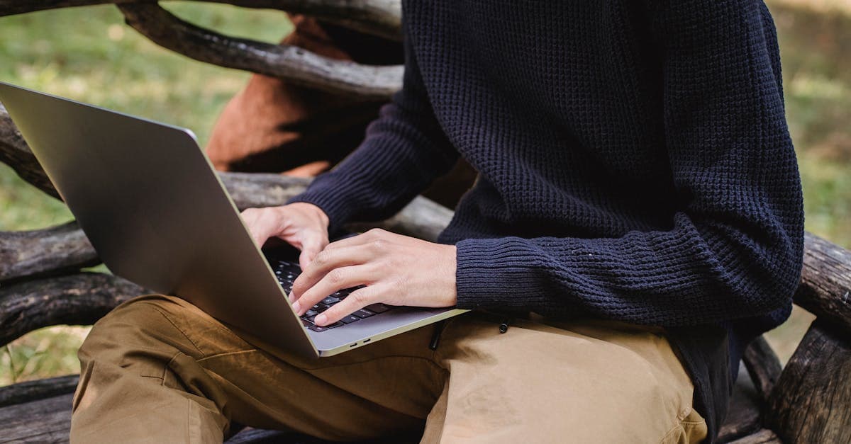 Man using a laptop on a park bench, choosing the best portable wifi hotspot for remote work travel