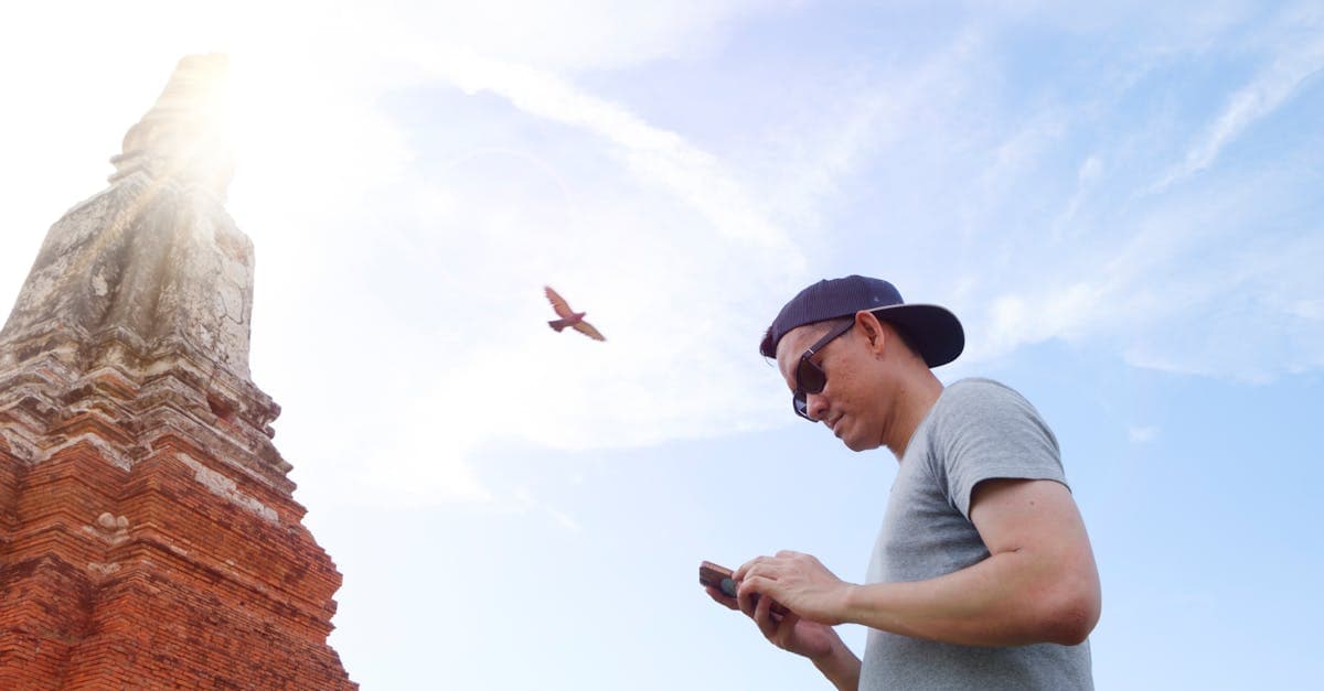 Traveller checking their phone near an ancient Bangkok temple after setting up an esim thailand before departure