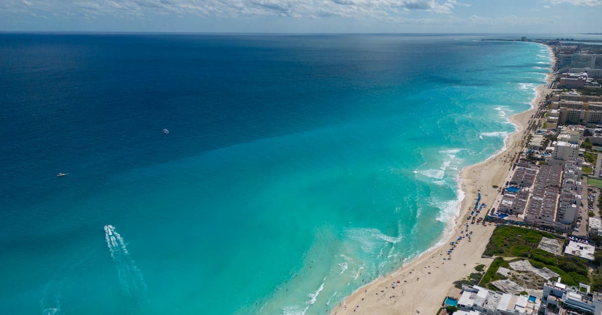 Aerial view contrasting Cancun's Hotel Zone luxury resorts and sandy beaches with downtown Cancun beyond