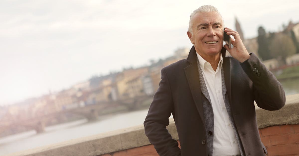 Uomo anziano in giacca utilizza smartphone in città per verificare la compatibilità eSIM con operatori giapponesi