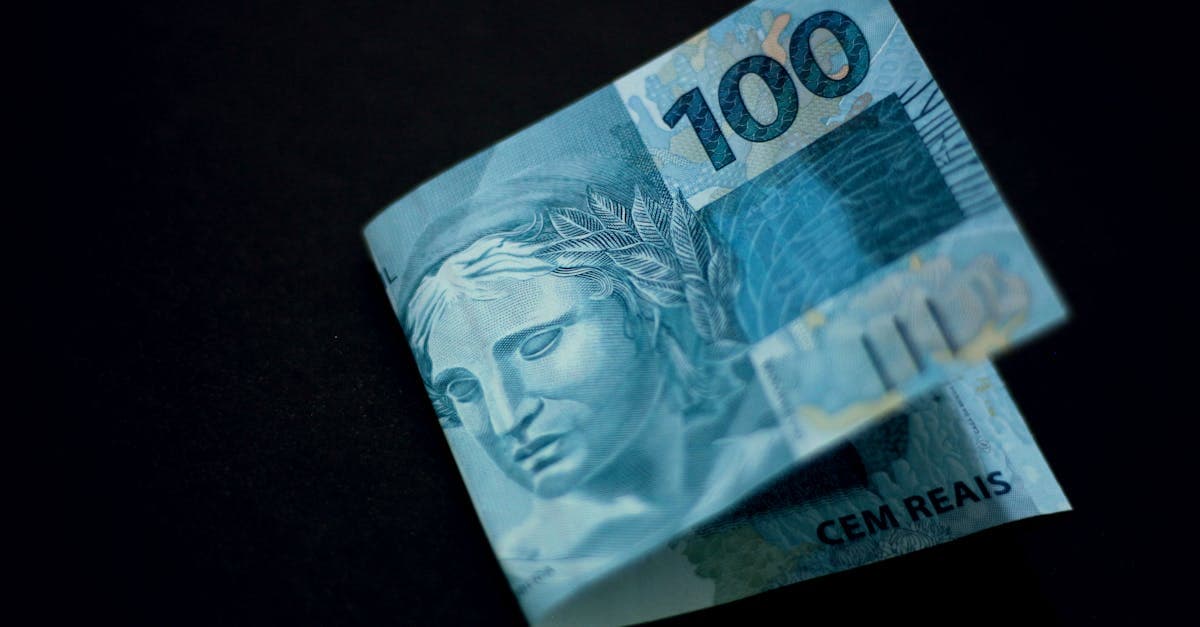 Nota de cem reais brasileiros sobre fundo preto, representando o orçamento para mochilão europa.