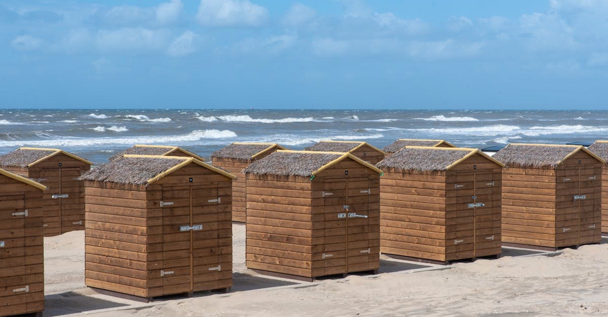 Strandhuisjes langs het zandstrand van Katwijk aan Zee op een zonnige zomerdag.