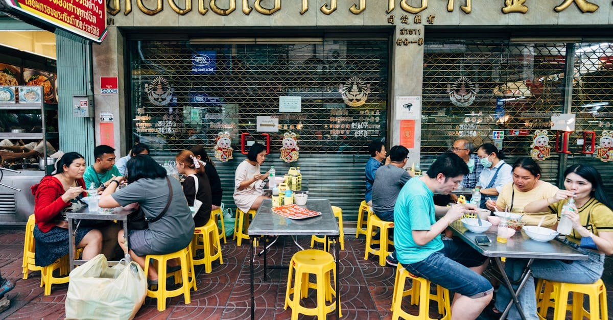 People enjoying street food thailand at outdoor tables and casual dining in Bangkok city.