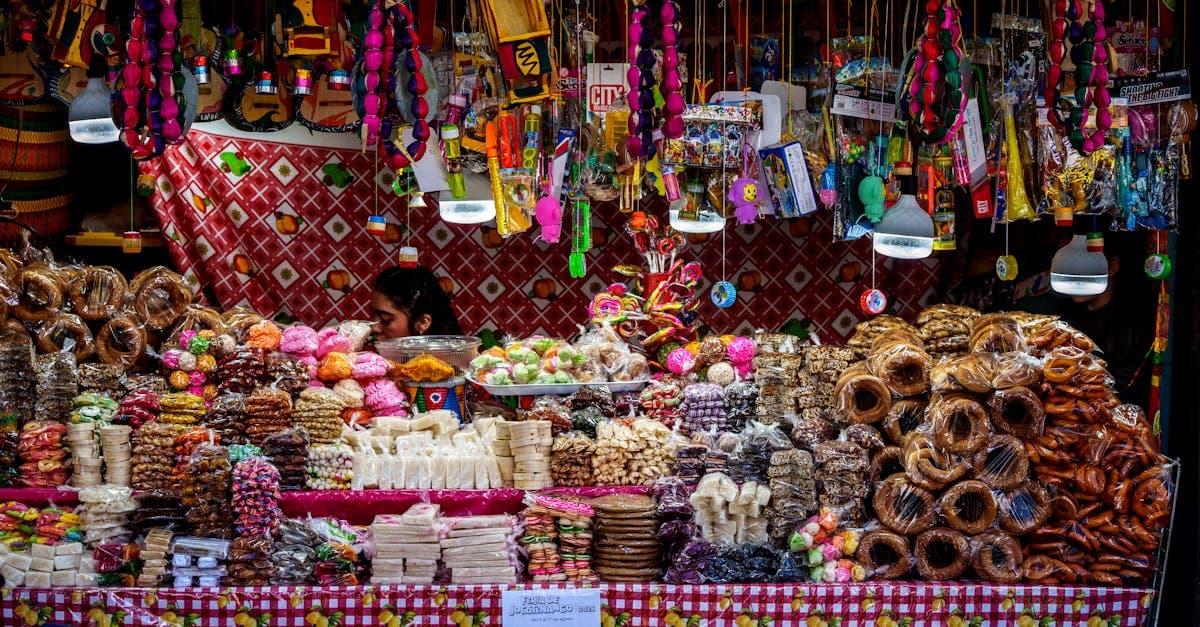 Puesto de gastronomía india callejera con dulces autóctonos y snacks tradicionales en mercado local