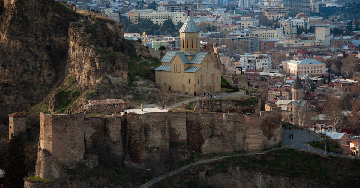 Aerial view of a historic Tbilisi church rising above the Georgian cityscape at golden hour