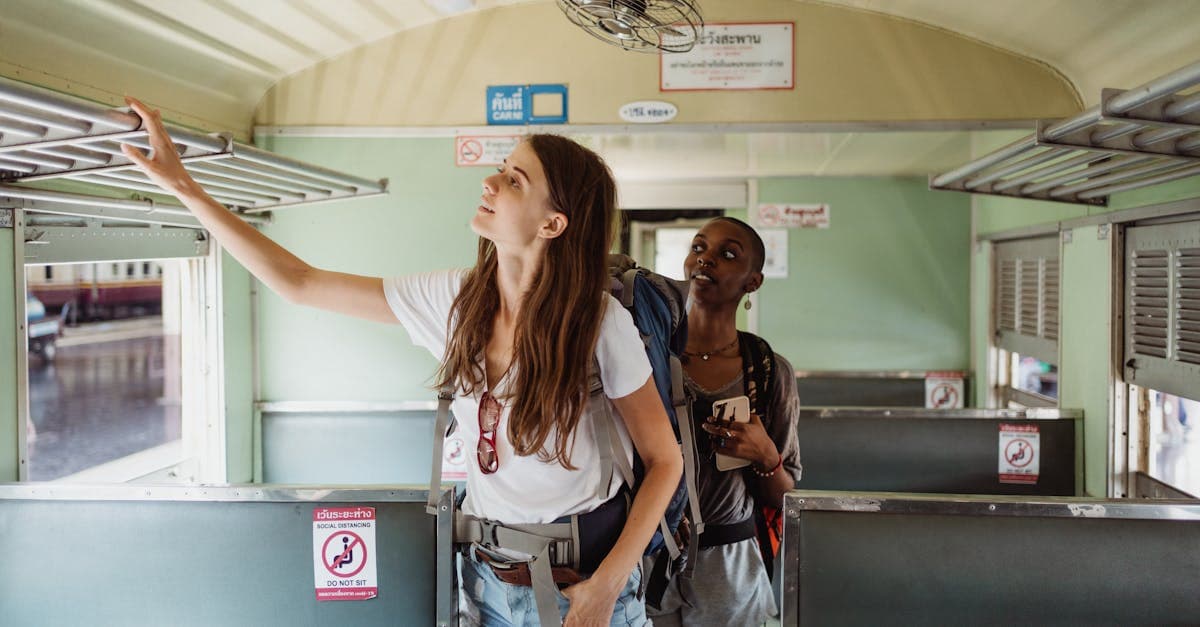Two backpackers storing bags in a train carriage, using traveling alone tips for India journeys