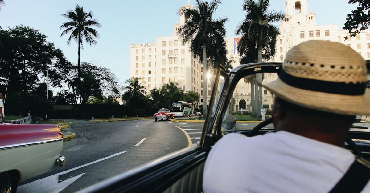 Taxi vintage décapotable devant l'Hôtel Nacional sous les palmiers, pour vos cheap trips to cuba