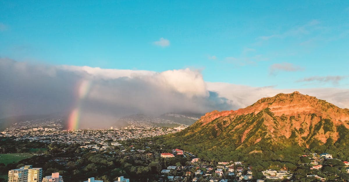 ハワイ天気の降水時期を示す虹とダイヤモンドヘッド、ホノルルの街並みを映した航空写真。