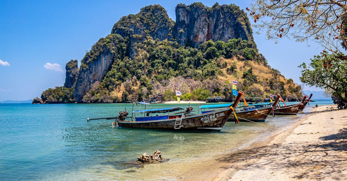 Idyllic Thai beach with traditional fishing boats, easily accessible to travellers with a reliable esim thailand
