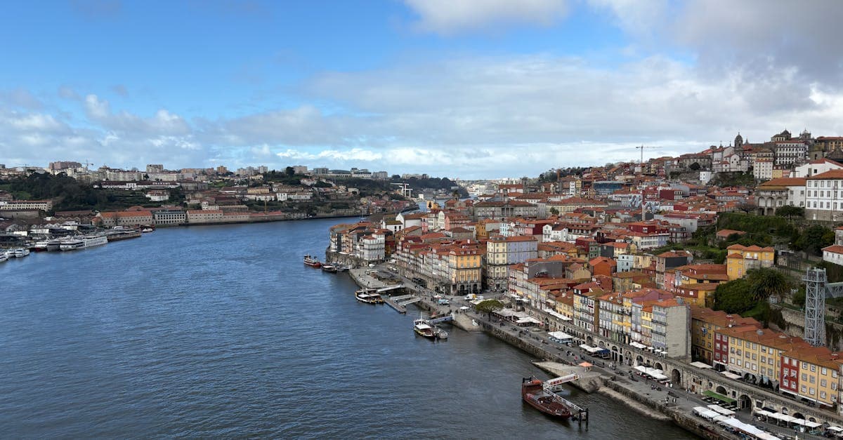 Vista panorâmica da orla do Porto ao longo do Rio Douro com edifícios históricos coloridos