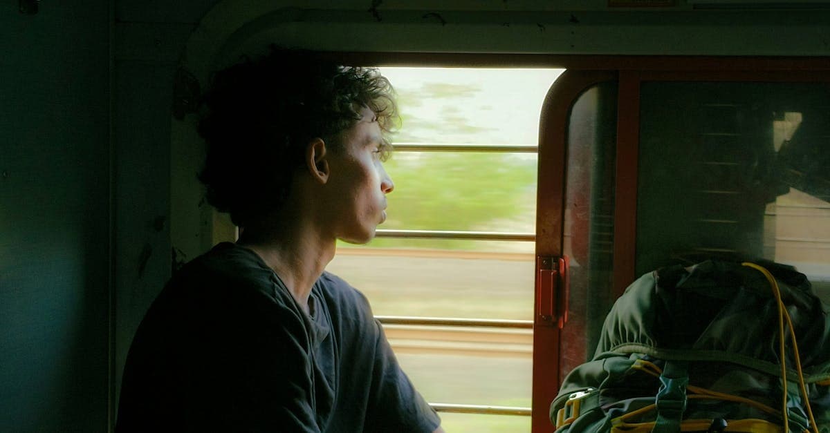 Voyageur solitaire regardant par la fenêtre d'un train en Inde, conseils de sécurité pour voyage solo