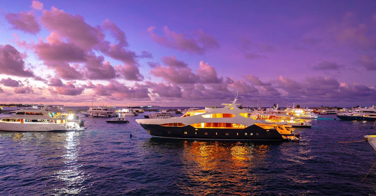 Yacht di lusso illuminati al tramonto alle Maldive: capire quando andare alle Maldive fa la differenza