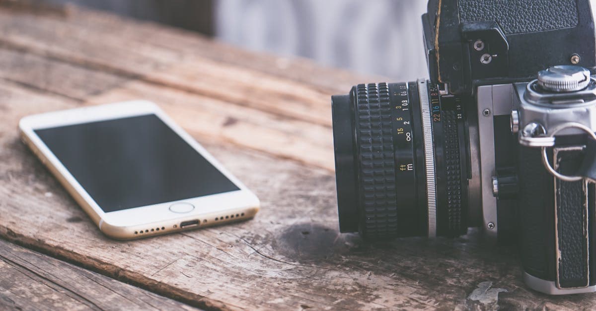 Vintage camera and smartphone on wooden table surface comparing portable wifi device setup solutions